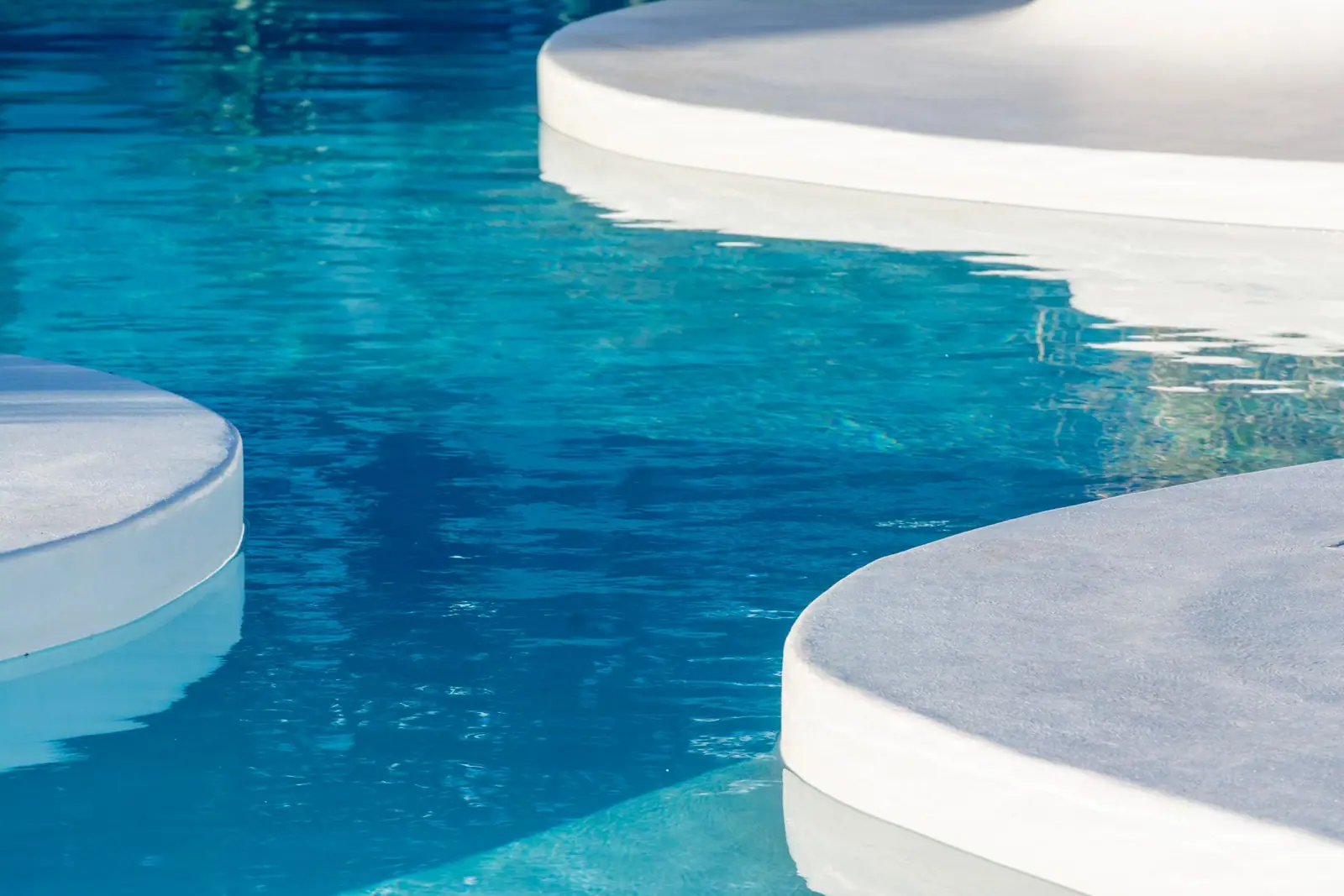 Curved pool steps in clear blue water