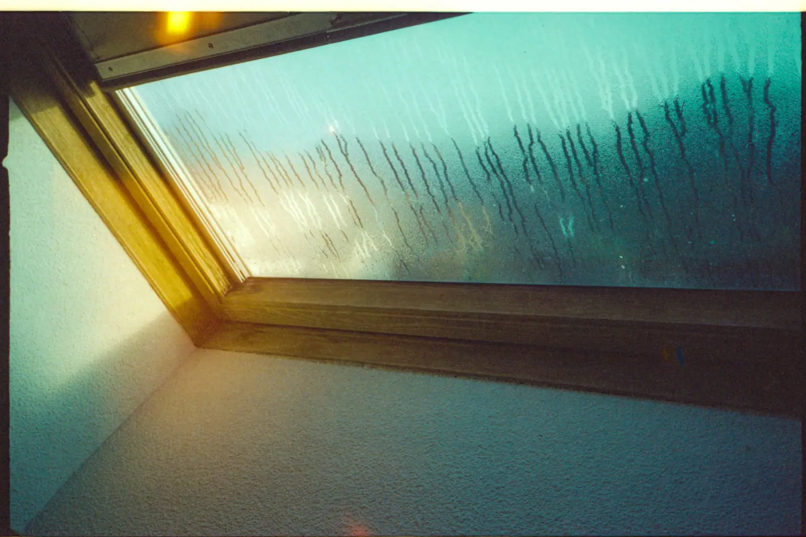 Water droplets on a skylight seen from inside a room