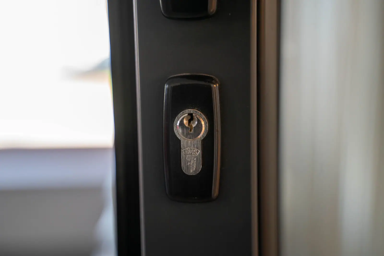 A close-up of a lock cylinder fitted to a dark door