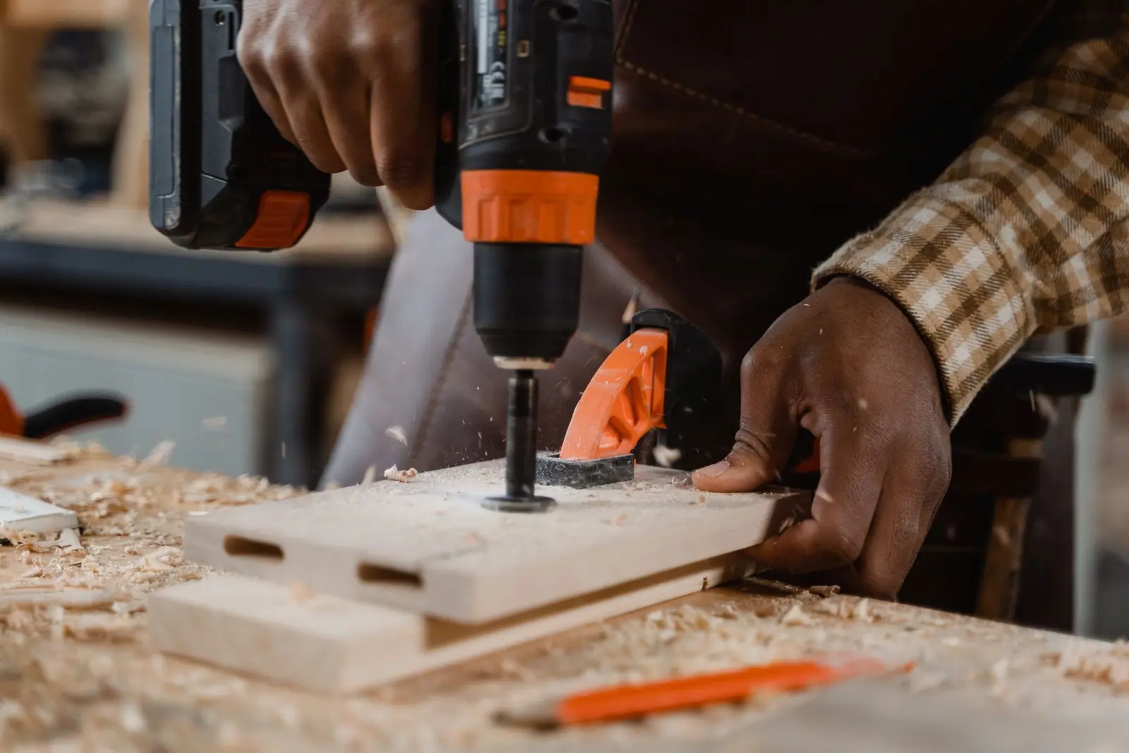 A worker driving a screw with a cordless drill