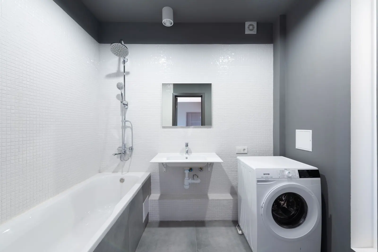 A white front-loading washing machine in a bathroom