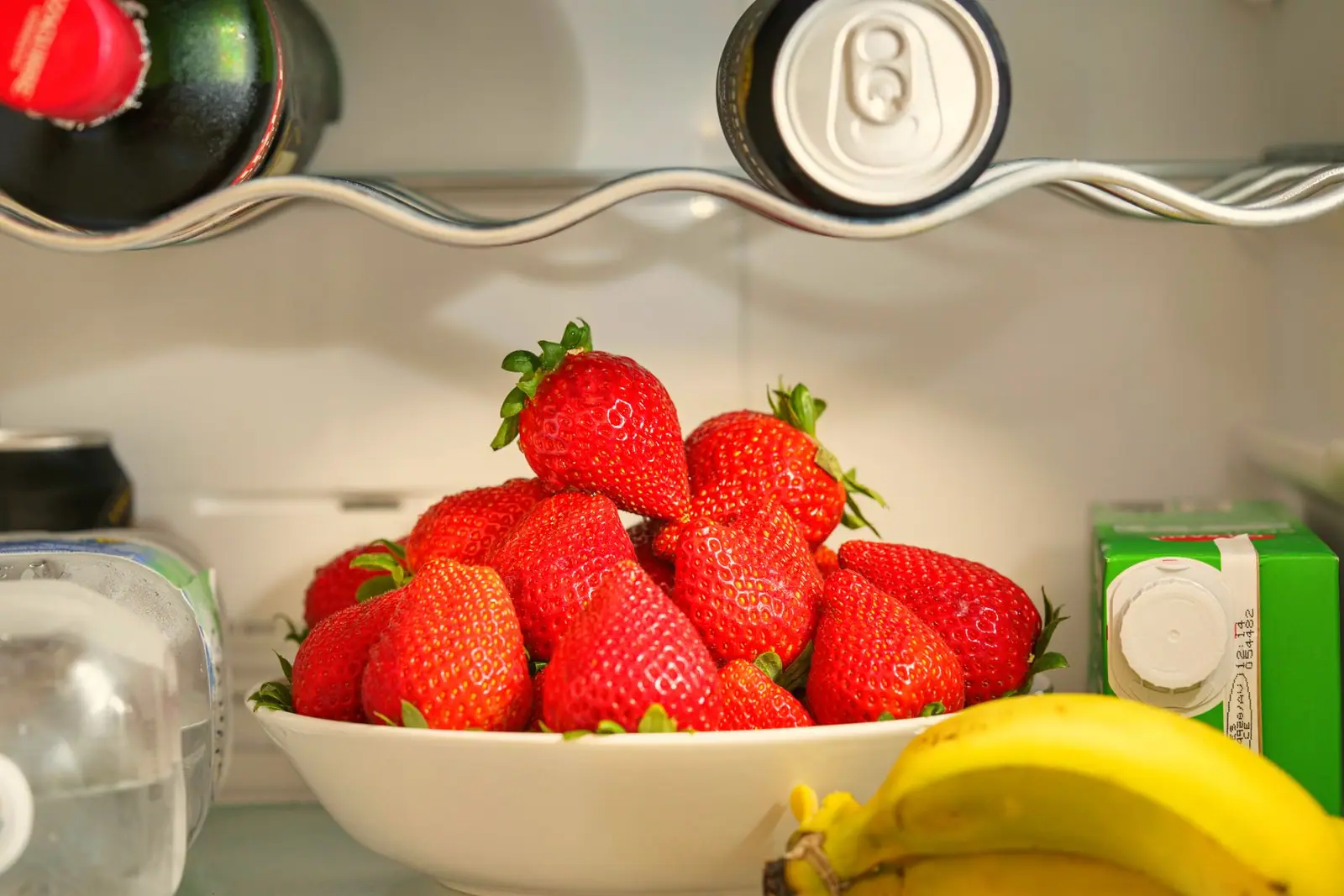 Fruit and food arranged on a refrigerator shelf