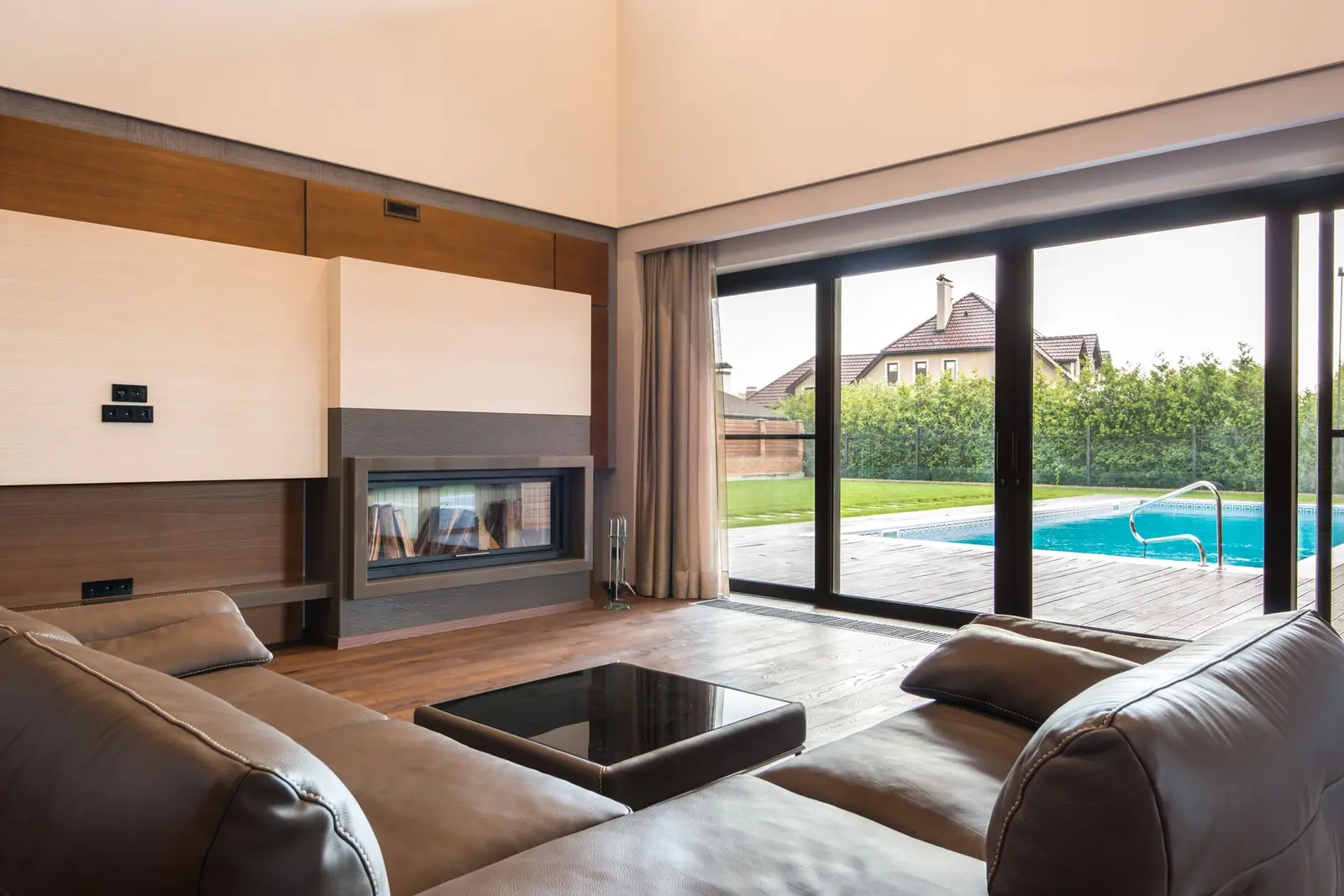 A living room with sliding glass doors looking out to a garden pool