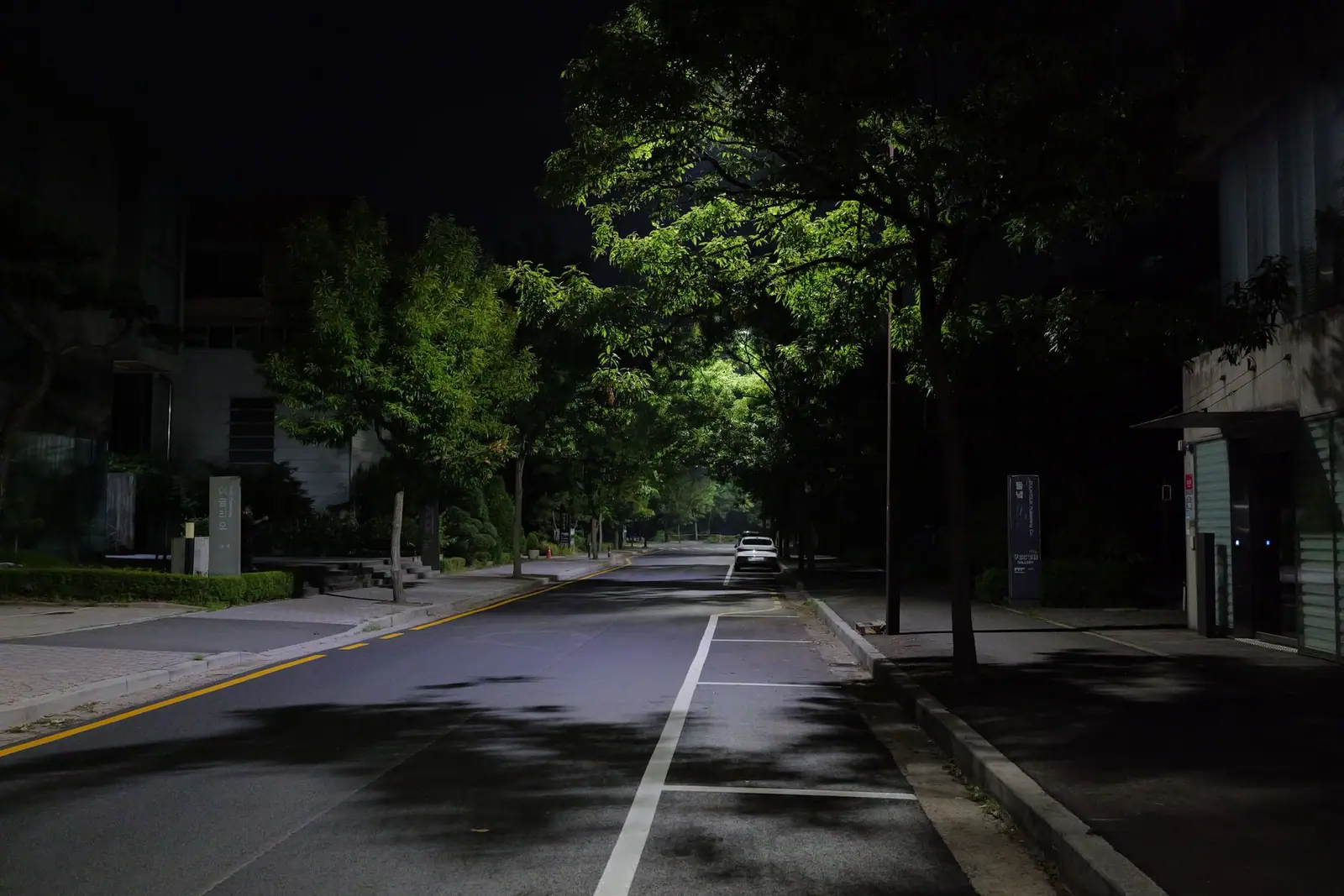 A dark residential street at night with almost no lighting