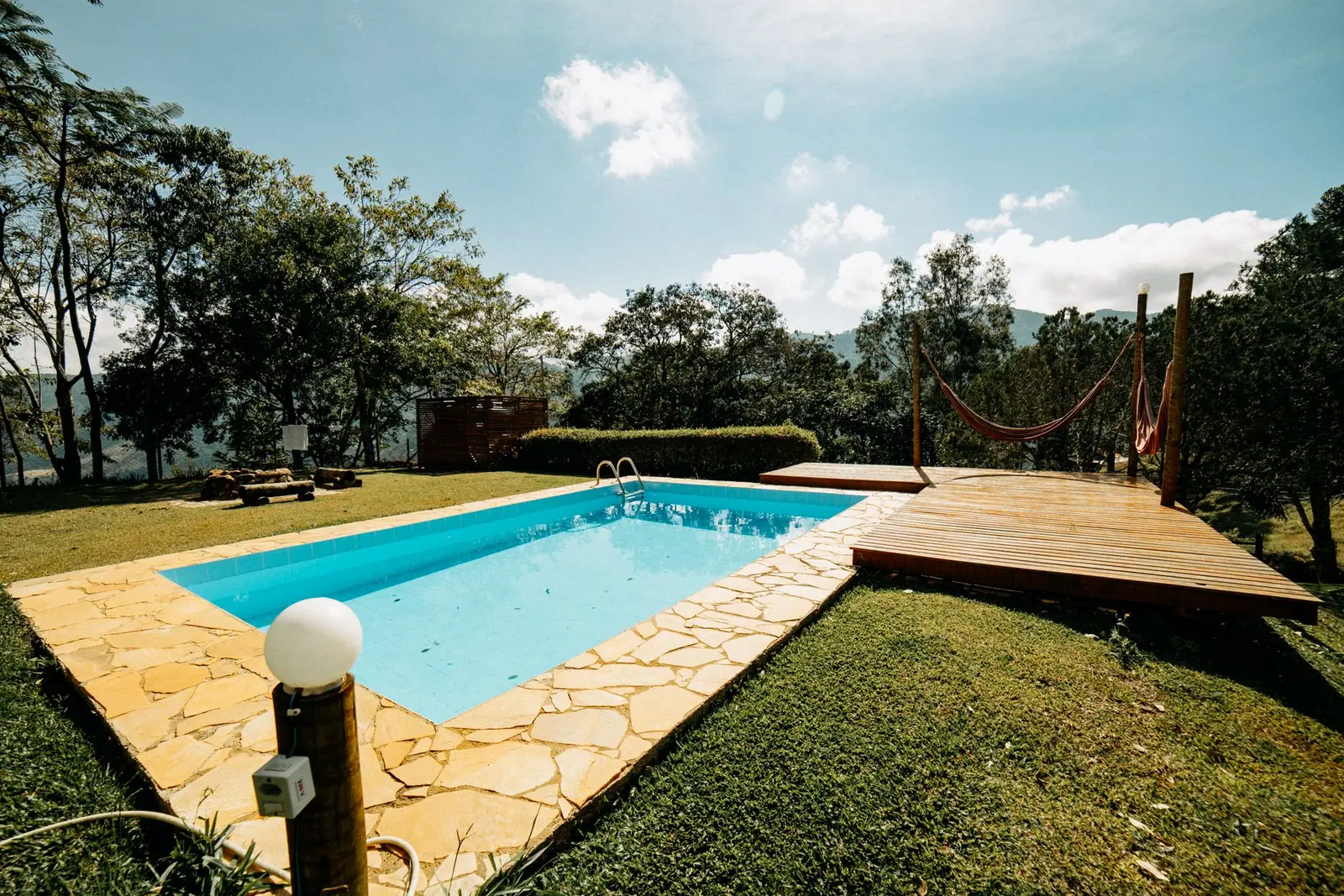 An outdoor swimming pool beside a landscaped garden