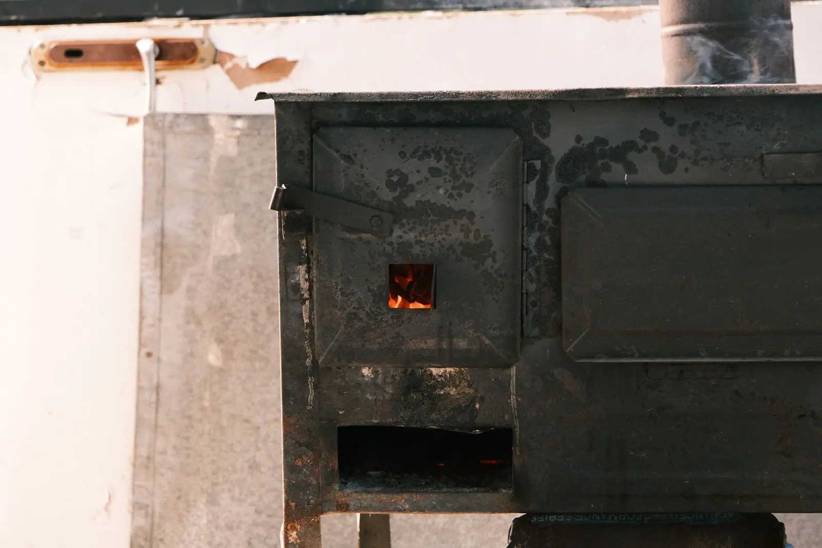 An old metal stove standing against a whitewashed wall