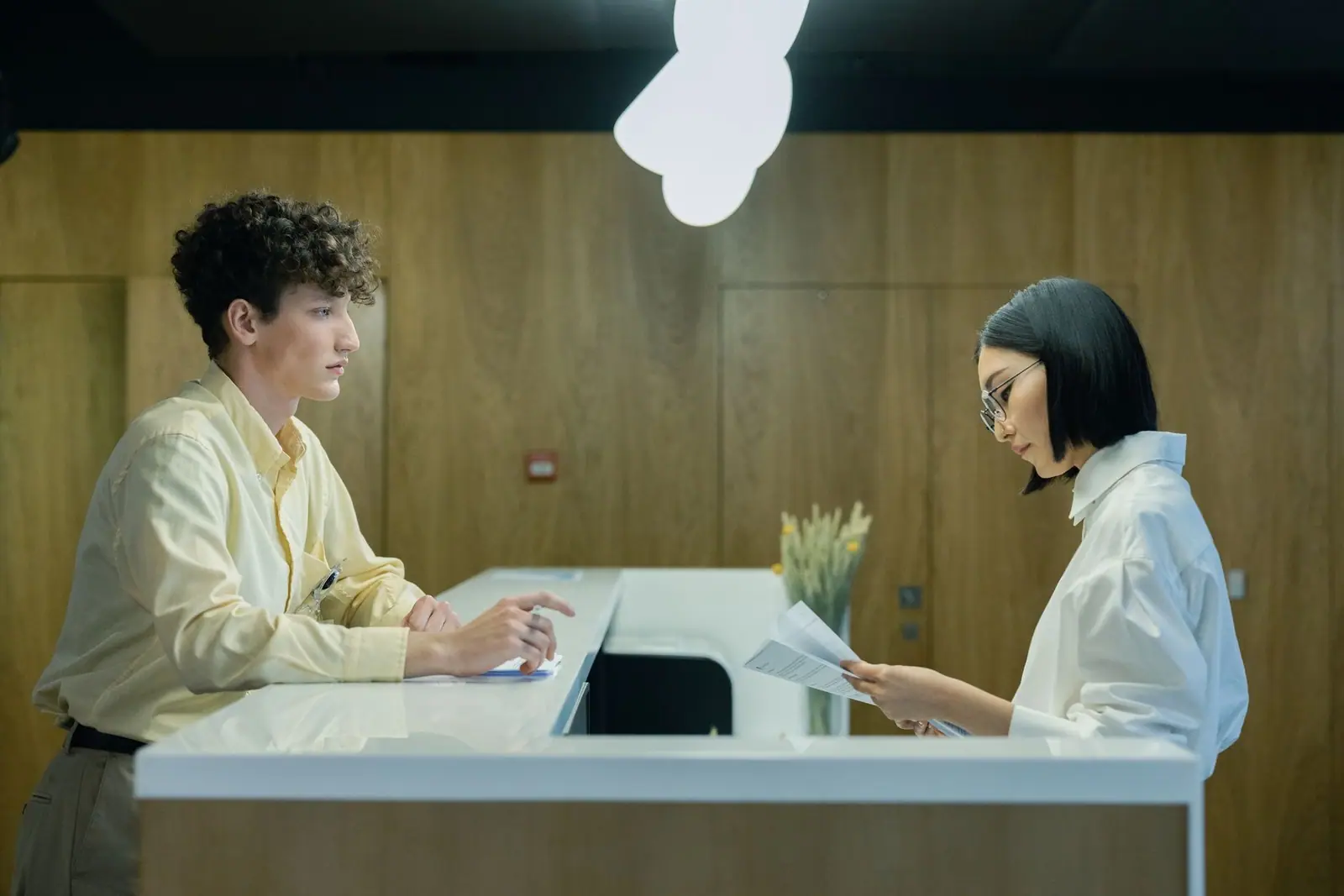 Two people talking across an office reception desk