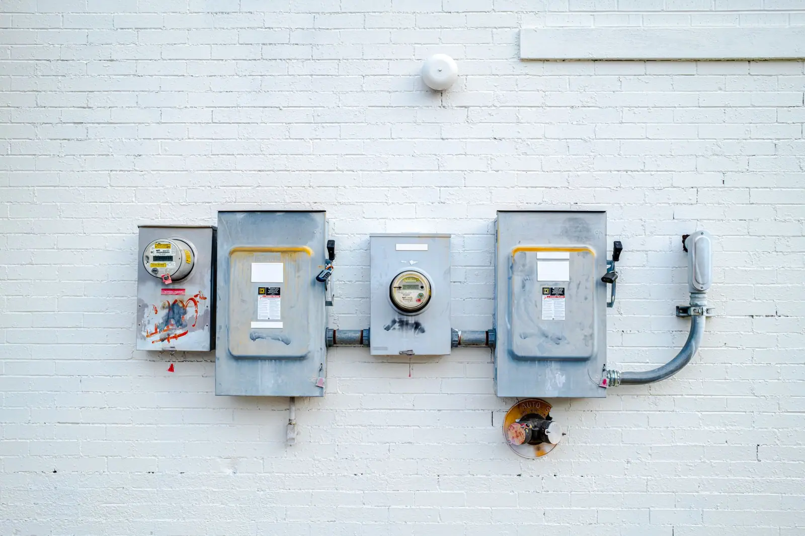 A row of electricity meters mounted on a white wall
