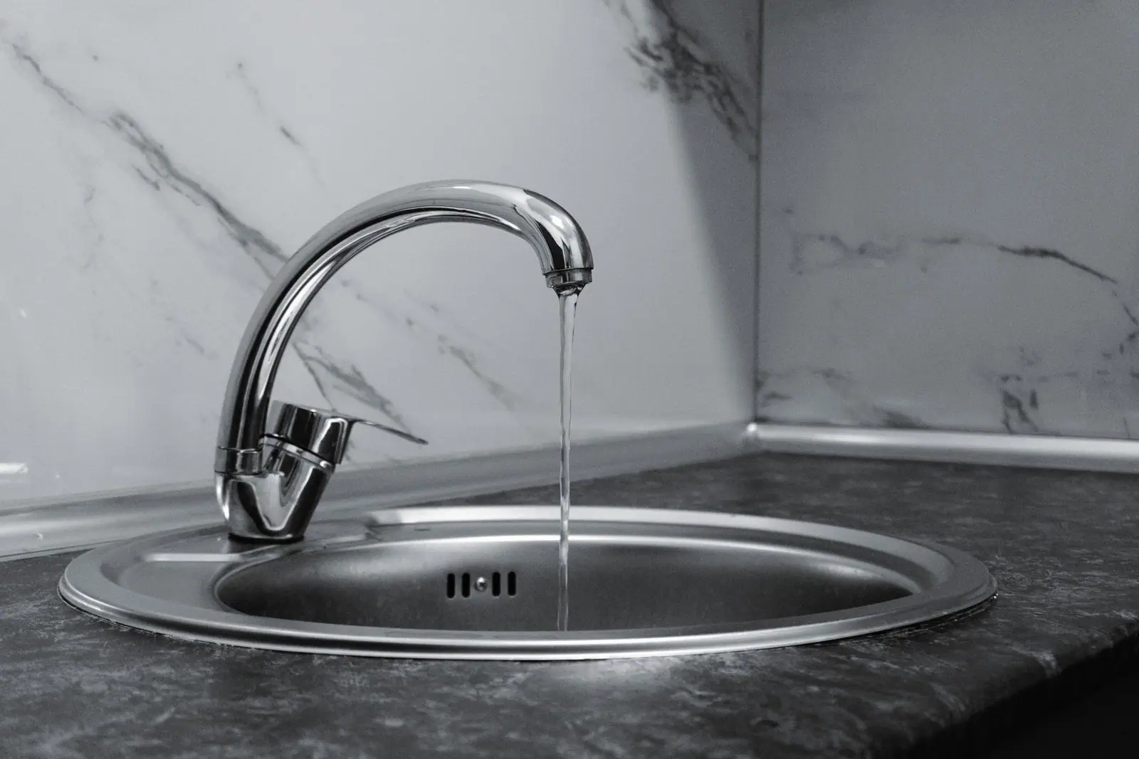 Water running from a chrome tap in a kitchen