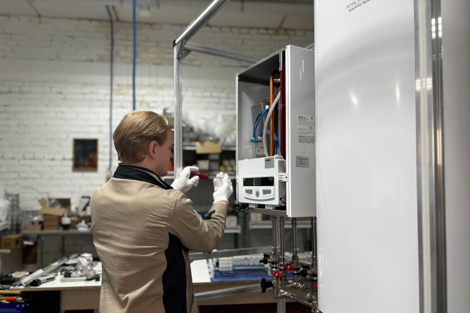 A technician servicing a wall-mounted water heater