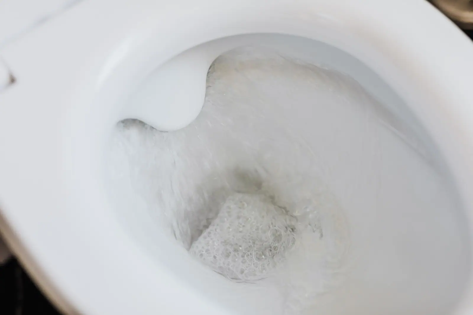 A toilet bowl seen from above with water flushing through it