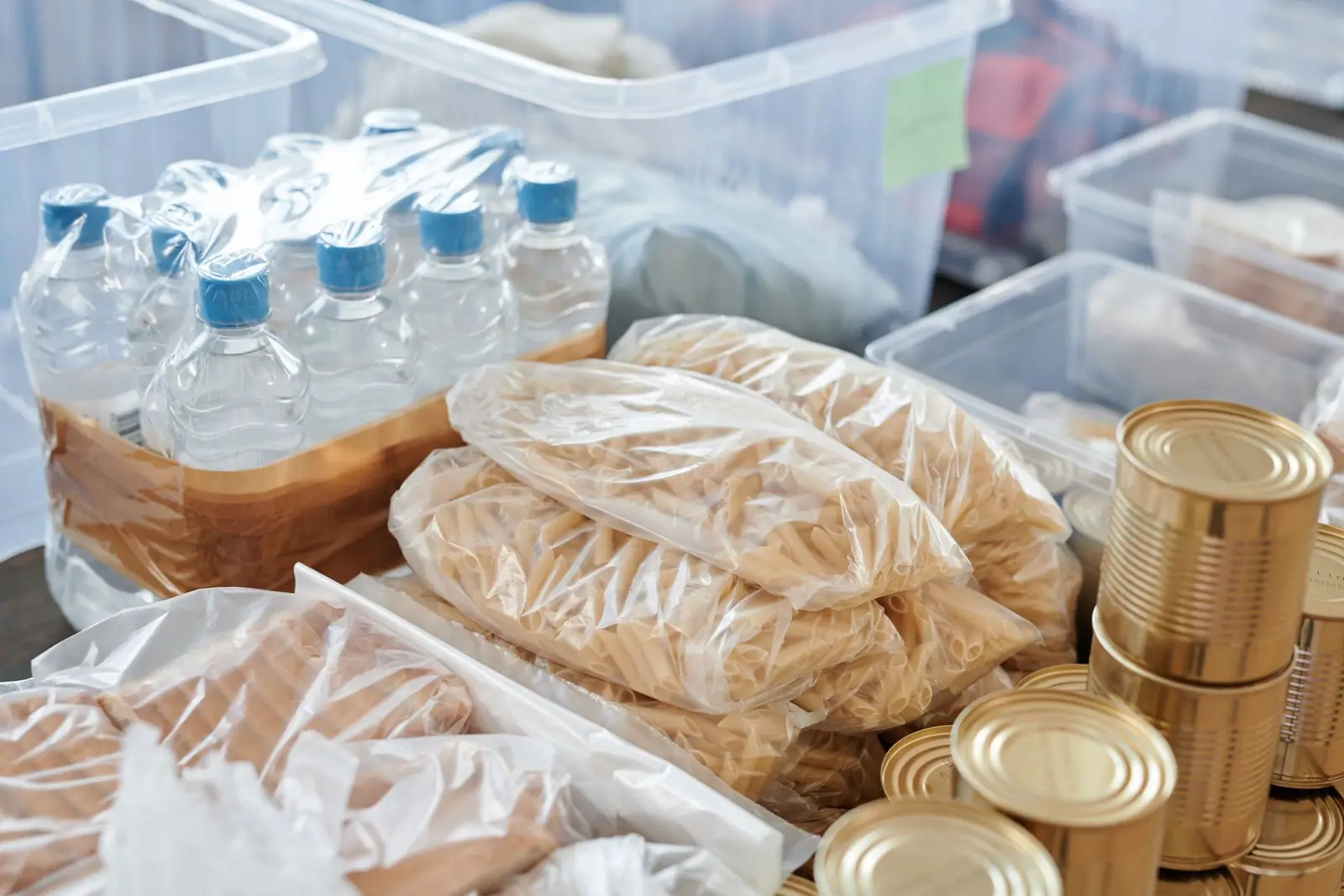 Bottled water, bagged food and tins stored in a plastic crate